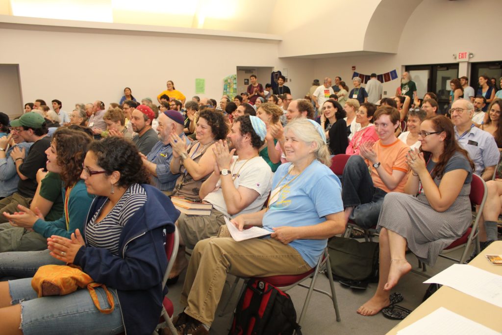 a gathering of 50+ people sitting in chairs